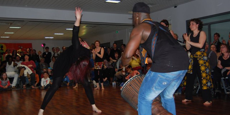 Danseurs et percussionnistes lors d'une performance vibrante à Feuguerolles-Bully, animant le public.