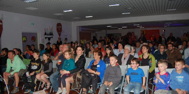 Public captivé lors d'un événement à Feuguerolles-Bully, avec une variété de spectateurs de tous âges.