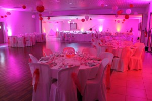 Salle de réception décorée en rose et rouge, prête pour un événement à Feuguerolles-Bully.