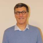 Portrait d'un homme souriant en pull bleu et lunettes, représentant la commune de Feuguerolles-Bully.