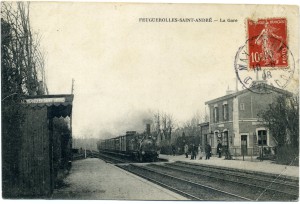Gare de Feuguerolles-Saint-André avec train à vapeur et passagers sur le quai, époque vintage.
