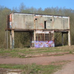 Bâtiment abandonné avec graffiti, situé dans un environnement naturel proche de Feuguerolles-Bully.