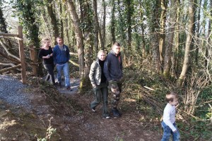 Promenade en forêt près de Feuguerolles-Bully, avec un groupe de personnes et un enfant sur un sentier.
