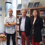 Cinq personnes se tiennent dans une bibliothèque, entourées de livres et de décorations lors d'un événement.