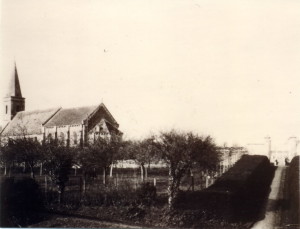 Église de Feuguerolles-Bully entourée de jardins, vue en noir et blanc.