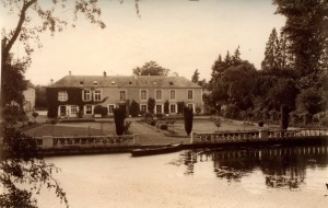 Vue d'un château ancien avec jardin, situé près d'un plan d'eau à Feuguerolles-Bully.