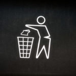 Pictogramme d'une personne jetant un déchet dans une poubelle.