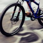 Jeune cycliste en mouvement sur une route, promesse d'aventures en pleine nature à Feuguerolles-Bully.