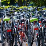 Station de vélos avec plusieurs bicyclettes garées, entourées de verdure à Feuguerolles-Bully.