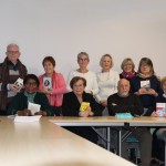Groupe de personnes souriantes tenant des livres, lors d'un événement à Feuguerolles-Bully.