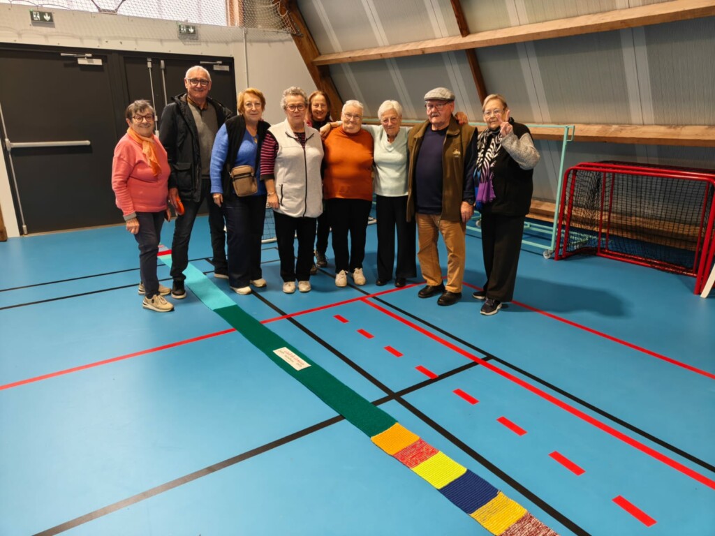 Groupe de personnes souriantes lors d'un événement dans une salle polyvalente à Feuguerolles-Bully.