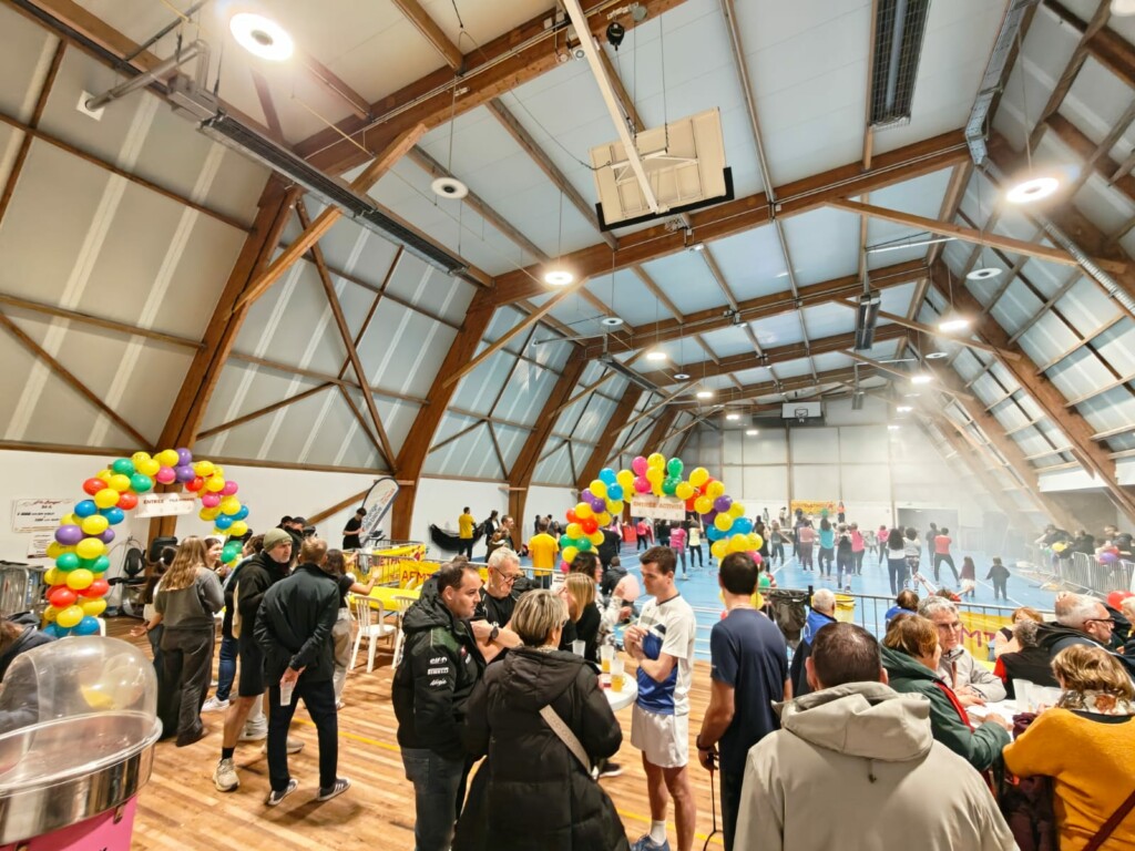 Événement festif dans une salle de sport, avec des décorations colorées et des participants animés à Feuguerolles-Bully.