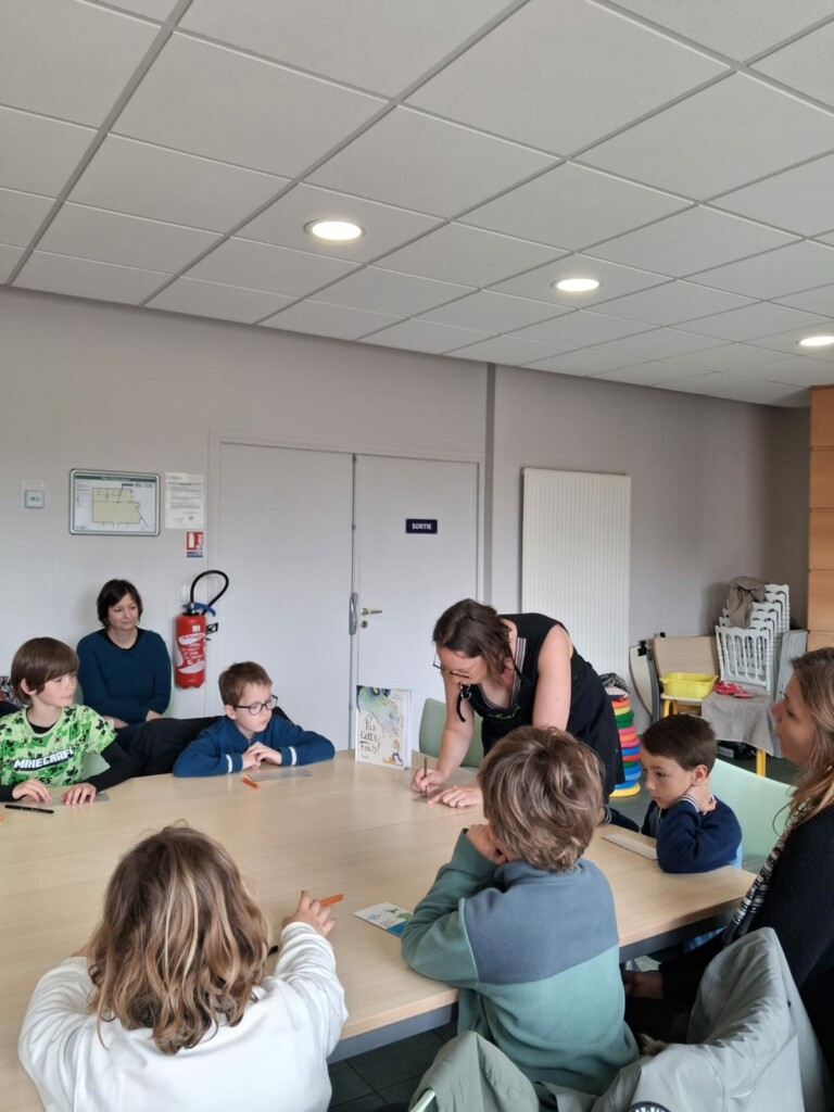 Atelier créatif avec des enfants autour d'une table dans une salle de la commune de Feuguerolles-Bully.