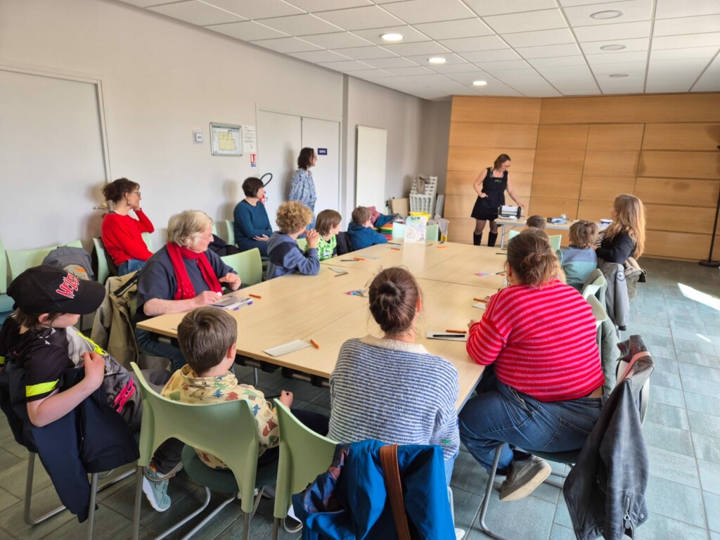 Atelier créatif réunissant adultes et enfants dans une salle de la commune de Feuguerolles-Bully.